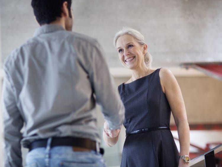 Man and woman greeting each other during an interview