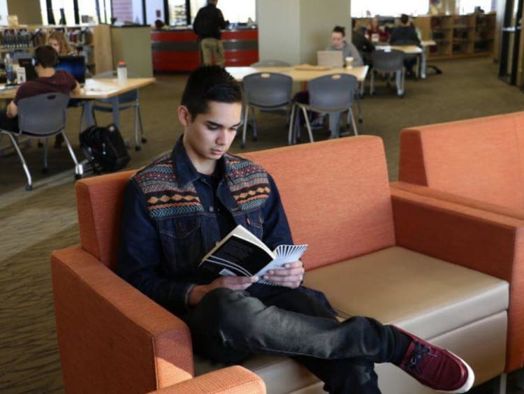 A GCU student reading in the library