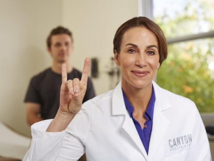 GCU nurse holding her hand in a lopes up