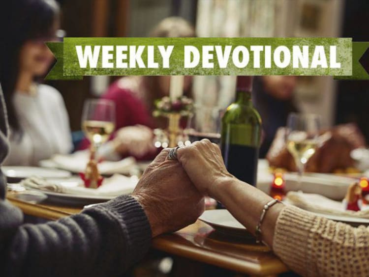 Weekly Devotional: Family praying over a dinner