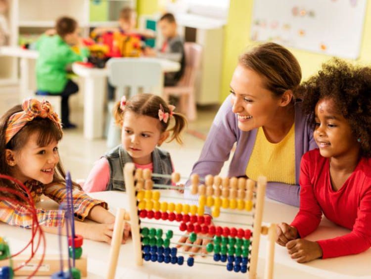 children playing in a classroom with an adult