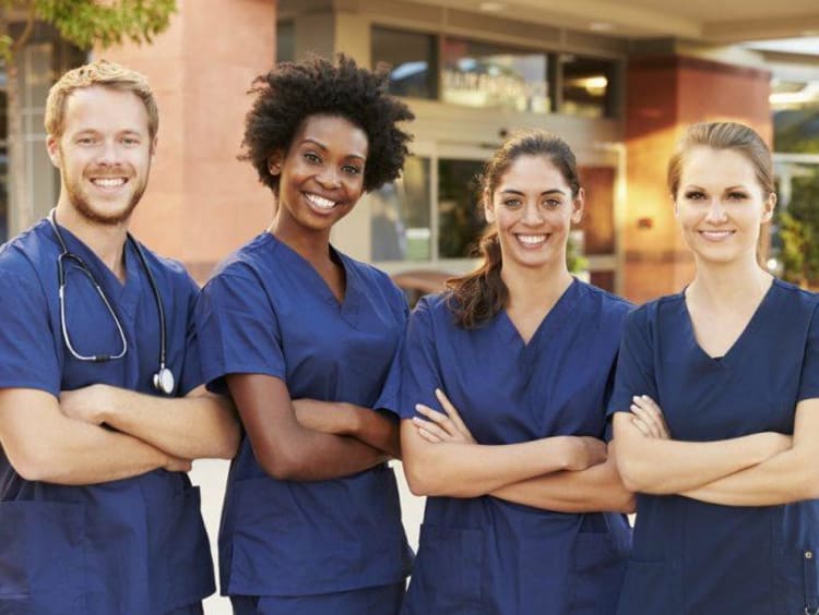 Four nurses standing with arms crossed