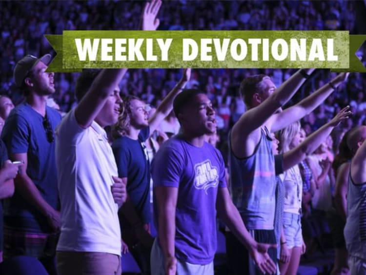 A group of students worshiping at Chapel under the Weekly Devotional banner