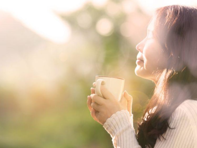 woman holding a coffee cup outside