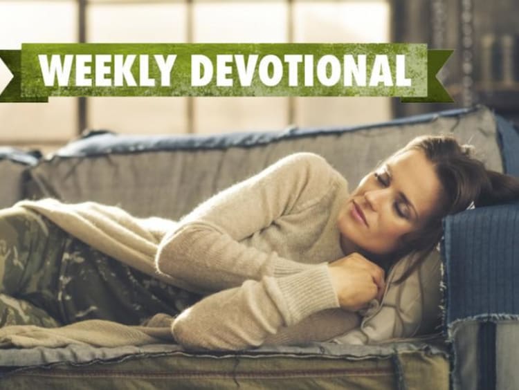 A student sleeping on the couch under a Weekly Devotional banner