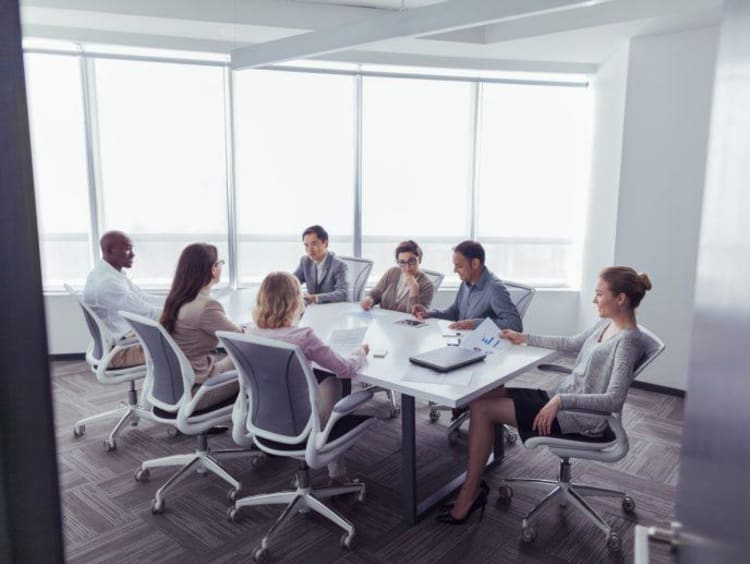 Conference room with professionals reviewing research proposals