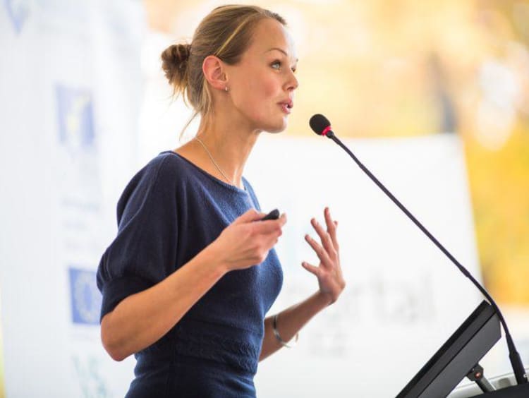 Adult woman speaking into microphone