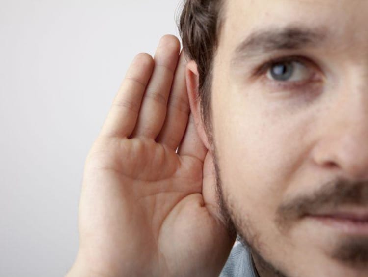 Man holding his hand to his ear to listen