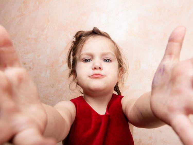 Young child reaching her arms out