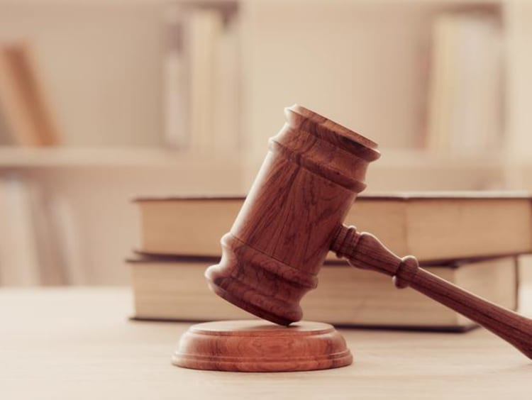 A gavel resting by a stack of books
