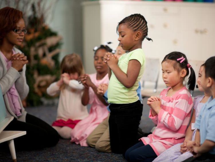 children praying in a class