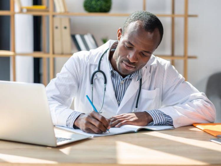 Concentrated brunette writing notes into copybook