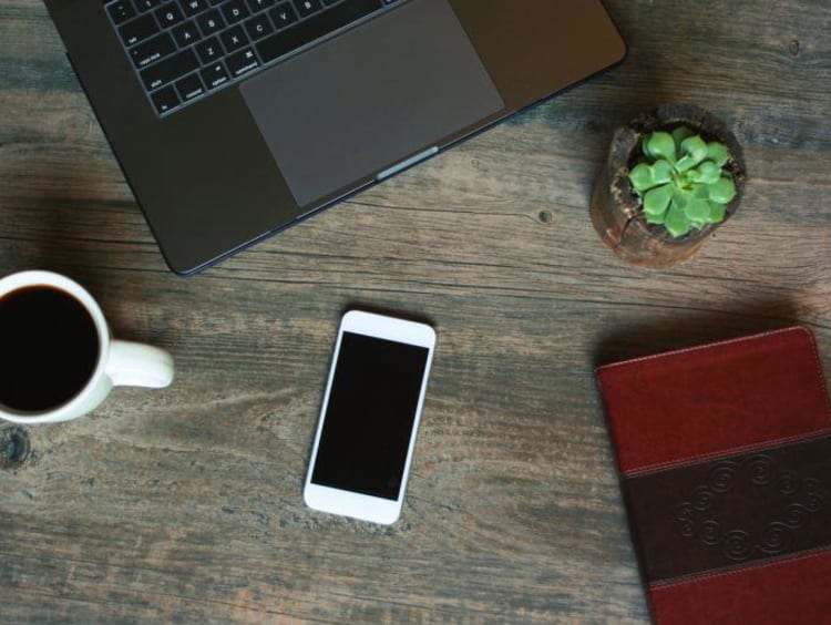 coffee cup phone and book on a table