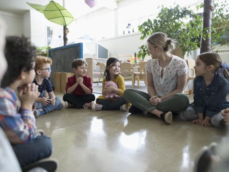 Students and a teacher gathered into a circle