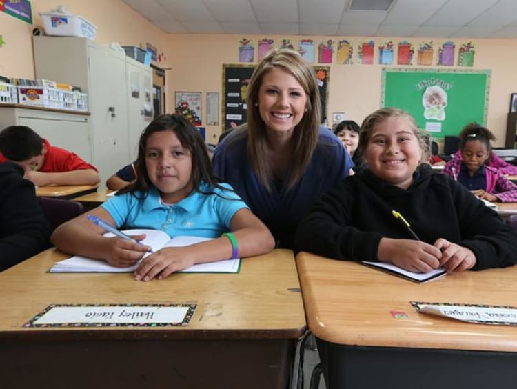 Woman teacher behind two students