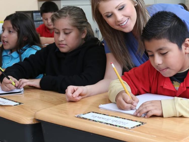 teacher helping her students in class