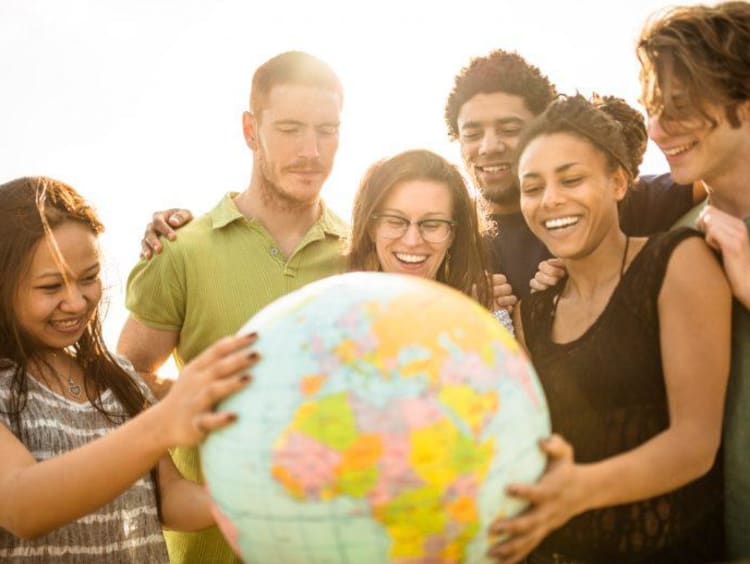 International students gathered around a globe