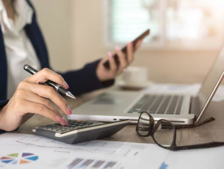 person looking at their phone at a desk