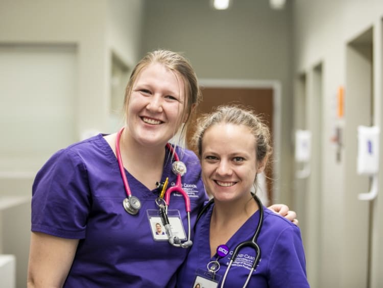 two GCU nurses standing in a hallway