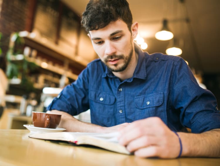 Man reading his Bible in a coffee shop