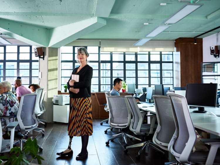 Woman standing in a room with with employees