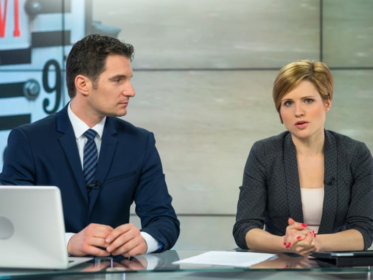 Two broadcast news analysts giving the news