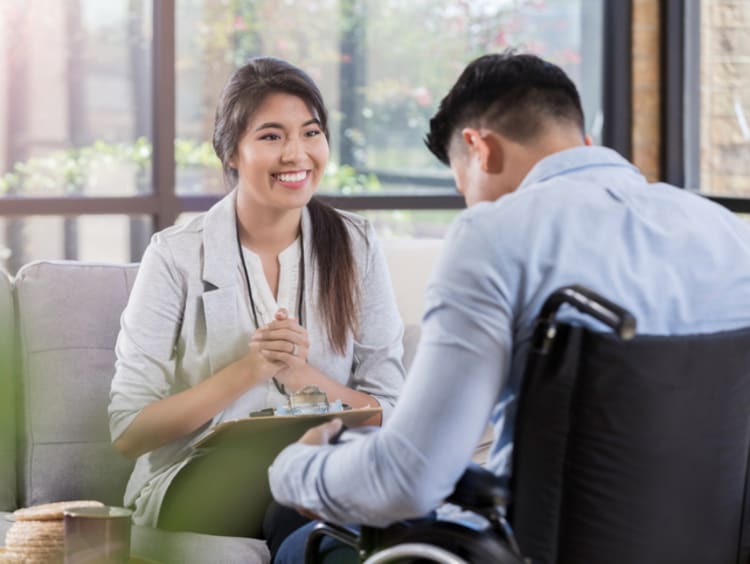 A vocational rehabilitation counselor talking with a man in a wheelchair to help him discover new career goals