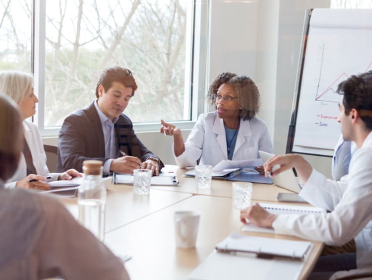 Female doctor discussing qualitative research data with her colleagues