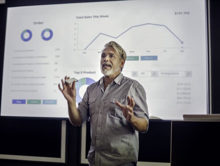 A male professor giving a lecture on quantitative data