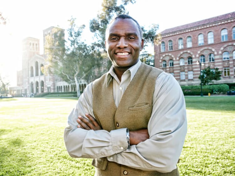 male EdS professor smiling outside of school building