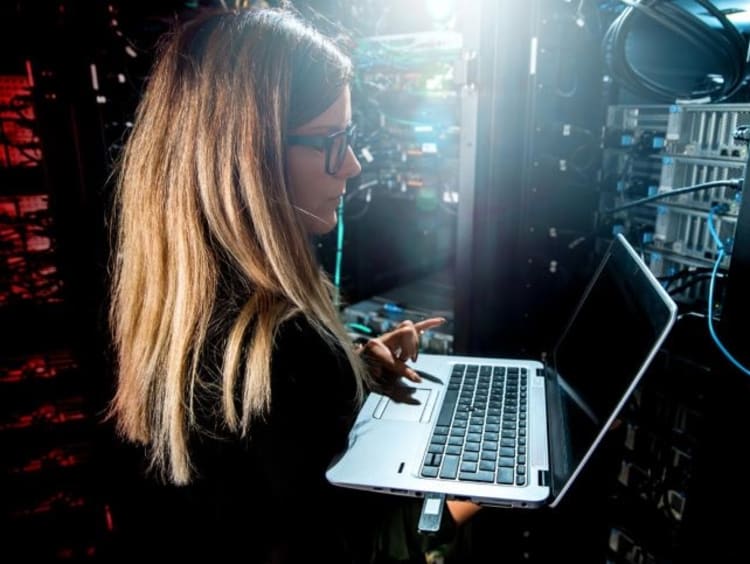 Female quality assurance analyst tests the functionality of a computer system