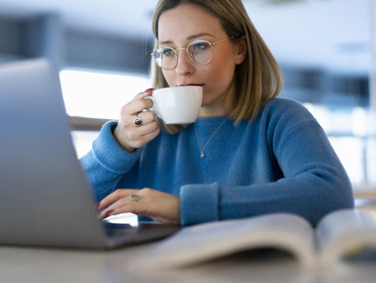 Student focusing on homework while drinking tea