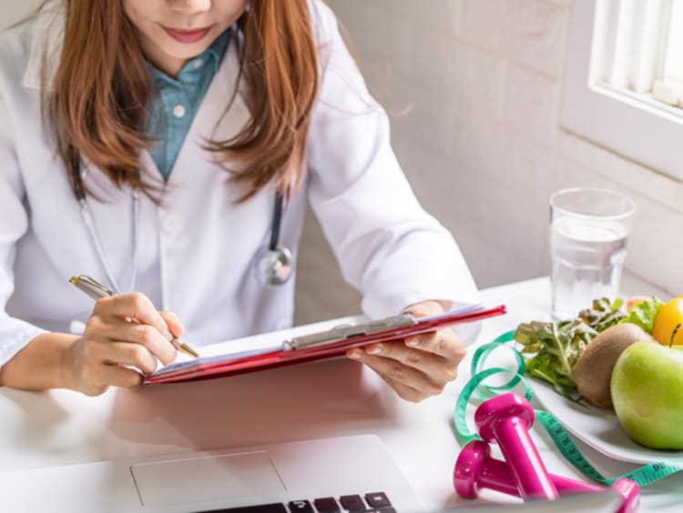 Female public health nutritionist reviewing a client's chart