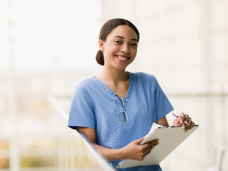 Female nursing student holding clipboard in lab room