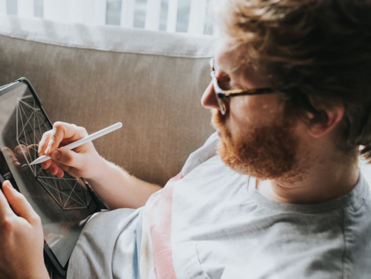 Male artist drawing a digital design on his tablet