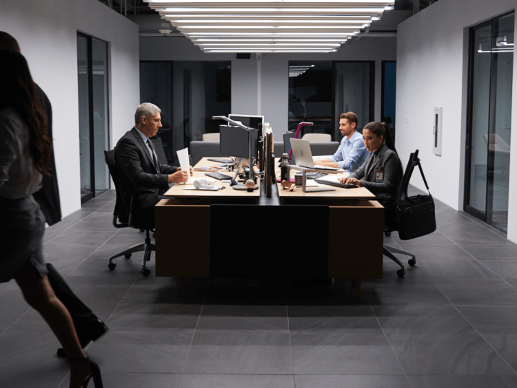 People sit at computers in office meeting setting