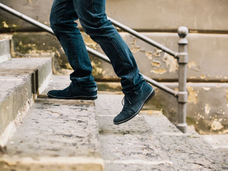 Man putting best foot forward while walking up stairs
