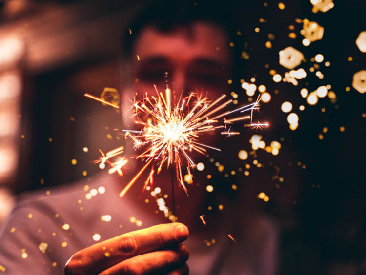 Man holding sparkler on New Year's Eve