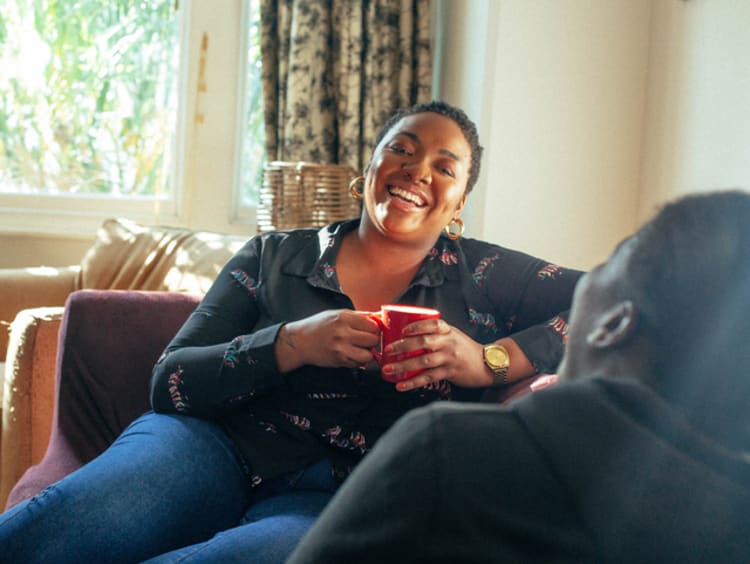 African-American woman having a conversation about faith with friend in a living room