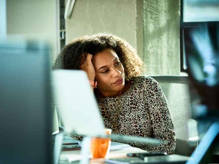 girl sitting at computer resting head against hand