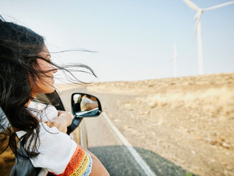 Young woman trusting in God's promises and smiling in car