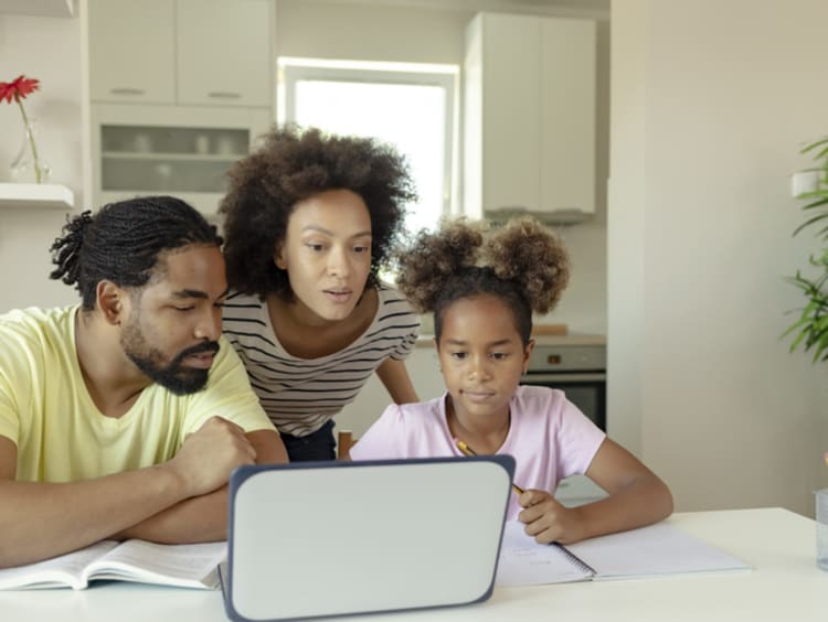 parents helping young child with online education