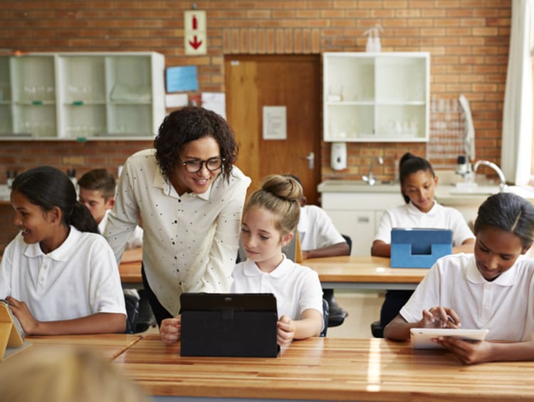 female teacher teaching young students in classroom learning environment