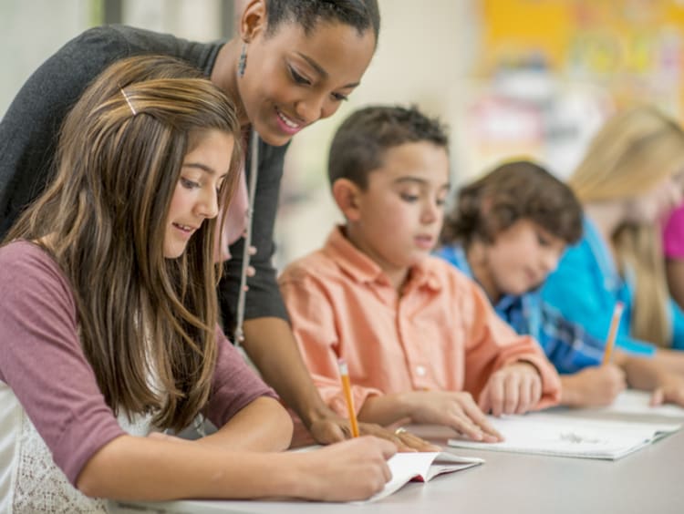 middle school teacher working with group of students