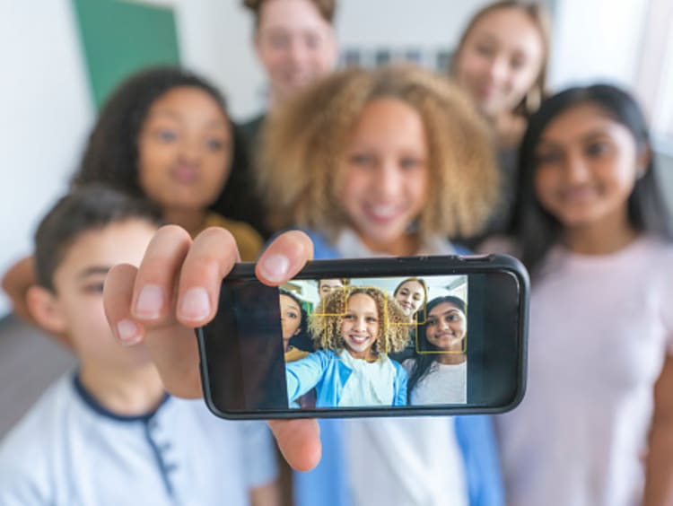 Teacher and students taking selfie for social media in classroom