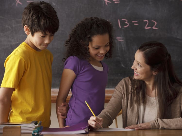 female teacher working with young co-ed students on practicing gratitude