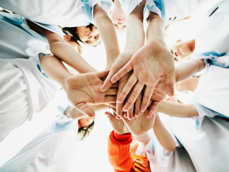 Team of hands representing the power of teamwork in education