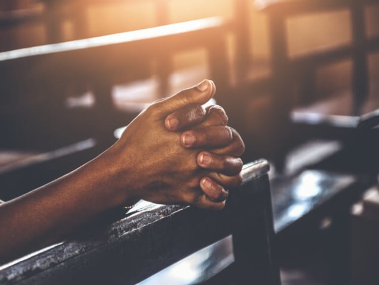 Hands clasped in prayer