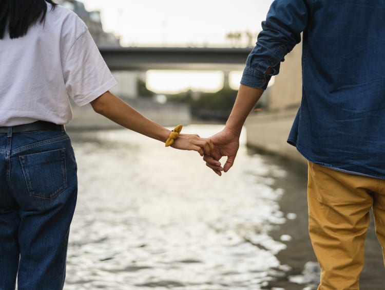 Couple holding hands by river