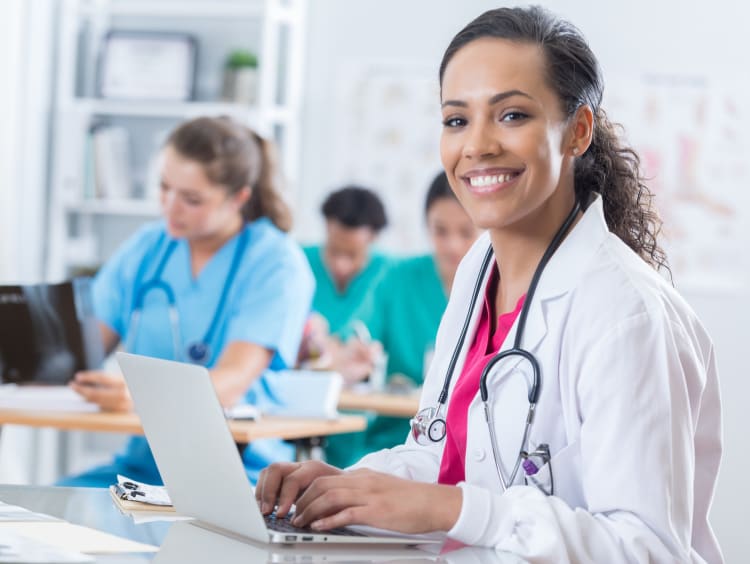 A woman in a lab coat smiling